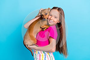 Photo of joyful young pretty small girl hold hands embrace dog lover isolated on pastel blue color background