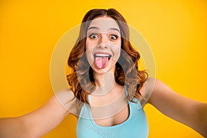 Photo of lady making selfies sticking tongue out of mouth wear tank-top isolated yellow background