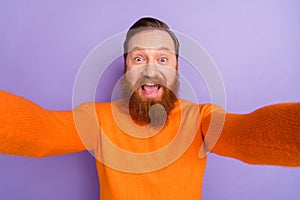 Photo of laughing crazy foxy man blogger take selfie making video from his trip isolated on violet color background