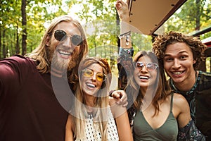 Photo of laughing hippie people men and women taking selfie in f