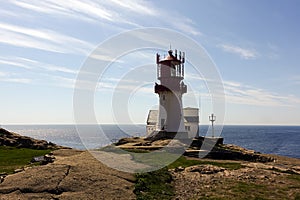 Photo of Lindesnes beacon in summer, South Norway. Aerial shot. Rocky sea coast and blue sky.