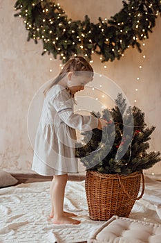 Photo of a little beautiful girl with a Christmas wreath