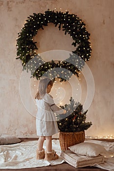 Photo of a little beautiful girl with a Christmas wreath