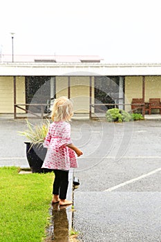Photo of little girl standing under rain in Greymouth, New Zealand