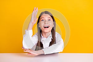 Photo of little impressed girl study wear white shirt isolated on yellow color background