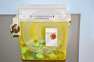 Photo of a locked yellow sharps container