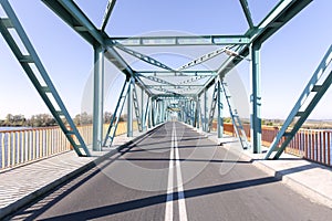 Photo of a long steel bridge over a river. photo