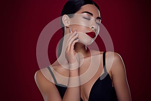 Photo of lovely asian young girl femme fatale closed eyes touch neck shoulders off  dark red color background