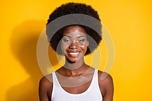 Photo of lovely black young girl look camera toothy smile wear white tank-top isolated yellow color background