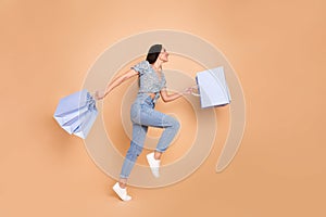 Photo of lovely cheerful woman wear blue trendy clothes hold packages blank space isolated on beige color background