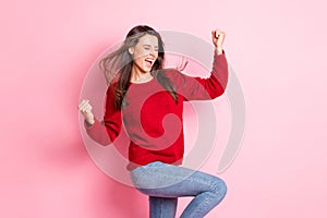 Photo of lovely girl closed eyes open mouth raise arms knee wear red sweater denim jeans isolated pink color background