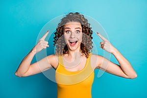 Photo of lovely lady opened mouth directing fingers herself head beaming smiling wear yellow singlet isolated blue color