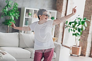 Photo of lovely mature lady dancing dressed white garment modern living room rest enjoy weekend free leisure time alone