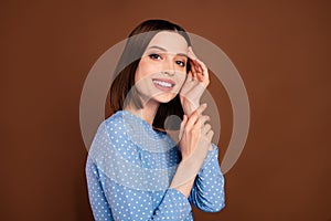 Photo of lovely short hairdo young lady touch face wear blue blouse isolated on brown color background