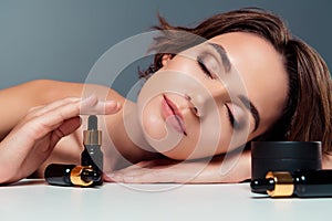 Photo of lovely young lady closed eyes facial treatment products shoulders off isolated on gray color background