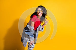 Photo of lovely young lady tongue-out show horns wear red t-shirt striped jeans jacket sunglass isolated yellow color