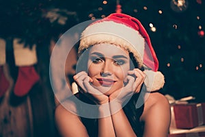 Photo of lovely young woman palms face look camera smile dream tease wear santa xmas headwear indoors