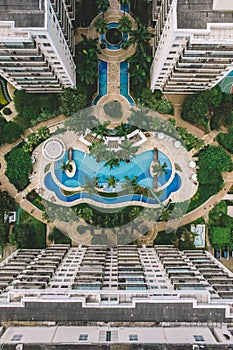 Photo of a luxurious outdoor swimming pool of the hotel surrounded by lush green palm trees