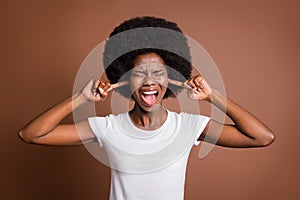 Photo of mad irritated lady scream closed eyes fingers ears wear white t-shirt isolated brown color background