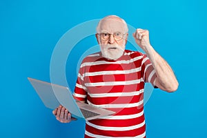 Photo of mad old grey hairdo man hold laptop wear red t-shirt isolated on bright blue color background