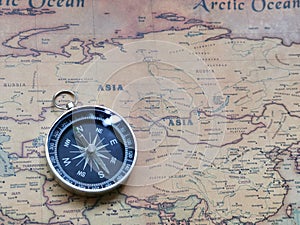 Photo of magnetic compass on world map.