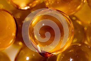 A photo of a magnificent texture of yellow bubbles obtained from spherical capsules of fish oil was taken in macro mode photo