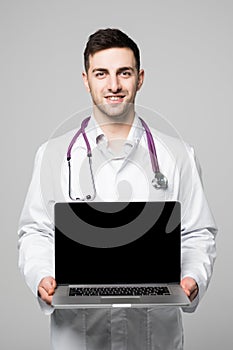 Photo of male doctor, smiling to camera and holding a laptop computer for the blank screen to add your own image of message on a w