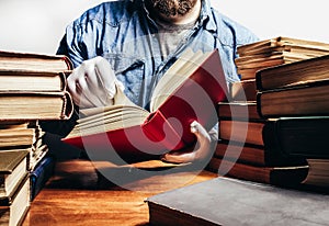 Photo of man in a blue shirt and white gloves holding and reading red book