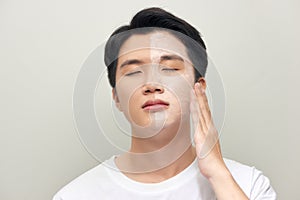 Photo of man with cosmetic clay mask on his face isolated over white background