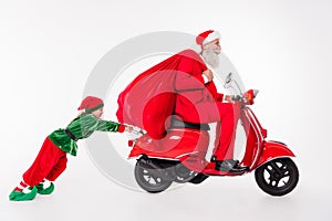 Photo of man drive moped hold presents bag kid push hard wear santa elf costume isolated grey color background