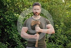 photo of man hold ax. man with ax. man with ax wearing shirt. man with ax outdoor