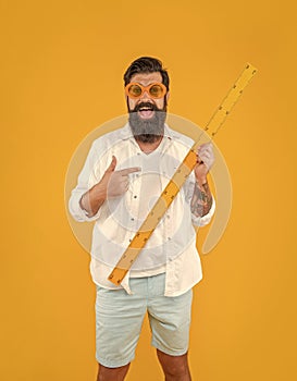 photo of man hold measuring ruler, point finger isolated on yellow in studio