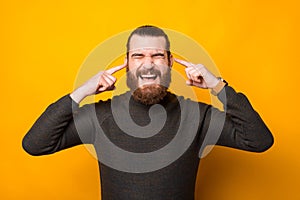 Photo of man putting fingers in ears and dont listen anything