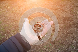 Photo of man`s hand with vintage compass