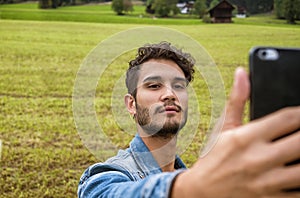 Photo of a man taking a selfie with his cell phone