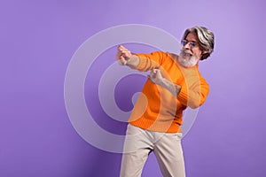 Photo of mature man happy positive smile carefree have fun dance party isolated over violet color background