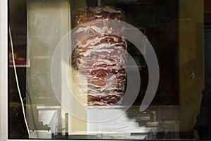 Photo of meat for shaurma cooking behind glass