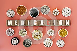 Photo on medication theme. wooden cubes with the inscription `medication`, and biologically active supplements,on coral background