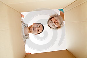Photo of man and woman peering into cardboard box photo