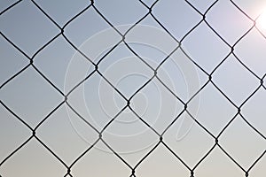 Photo of metal braided wire mesh with bright sun in the background