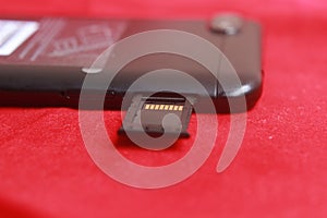 Photo Micro SD Card Memory in Slot at Smartphone at Red Background