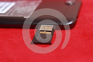 Photo Micro SD Card Memory in Slot at Smartphone at Red Background