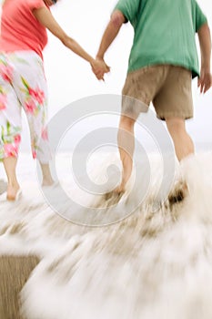 Photo of mid adult couple walking on the beach