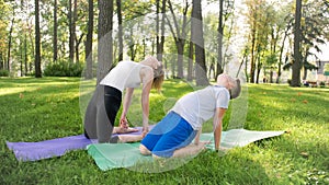 Photo of middle aged mother with her teenage boy child doing yoga and breathing exercises at park. Family taking care of