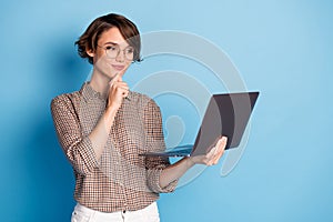 Photo of minded charming young woman hold hand chin laptop businesswoman isolated on blue color background