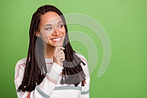 Photo of minded dreamy dark skin young woman look empty space think isolated on green color background