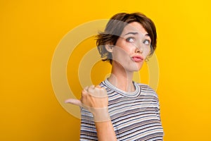 Photo of minded girl dressed stylish clothes thumb direct empty space suspicious offer isolated on yellow color