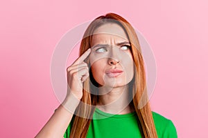 Photo of minded intelligent woman with ginger hair dressed green t-shirt look empty space finger on head isolated on