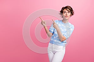 Photo of minded pretty lady look direct fingers empty space hesitate isolated on pink color background