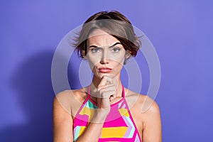 Photo of minded serious uncertain unsure woman arm touch chin raised brow hmm doubts  on purple color background